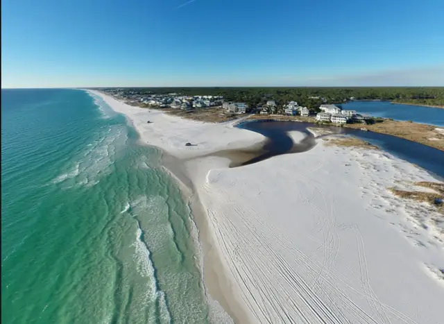 An aerial view of Grayton Beach, where Western Lake spills across the sand into the Gulf.